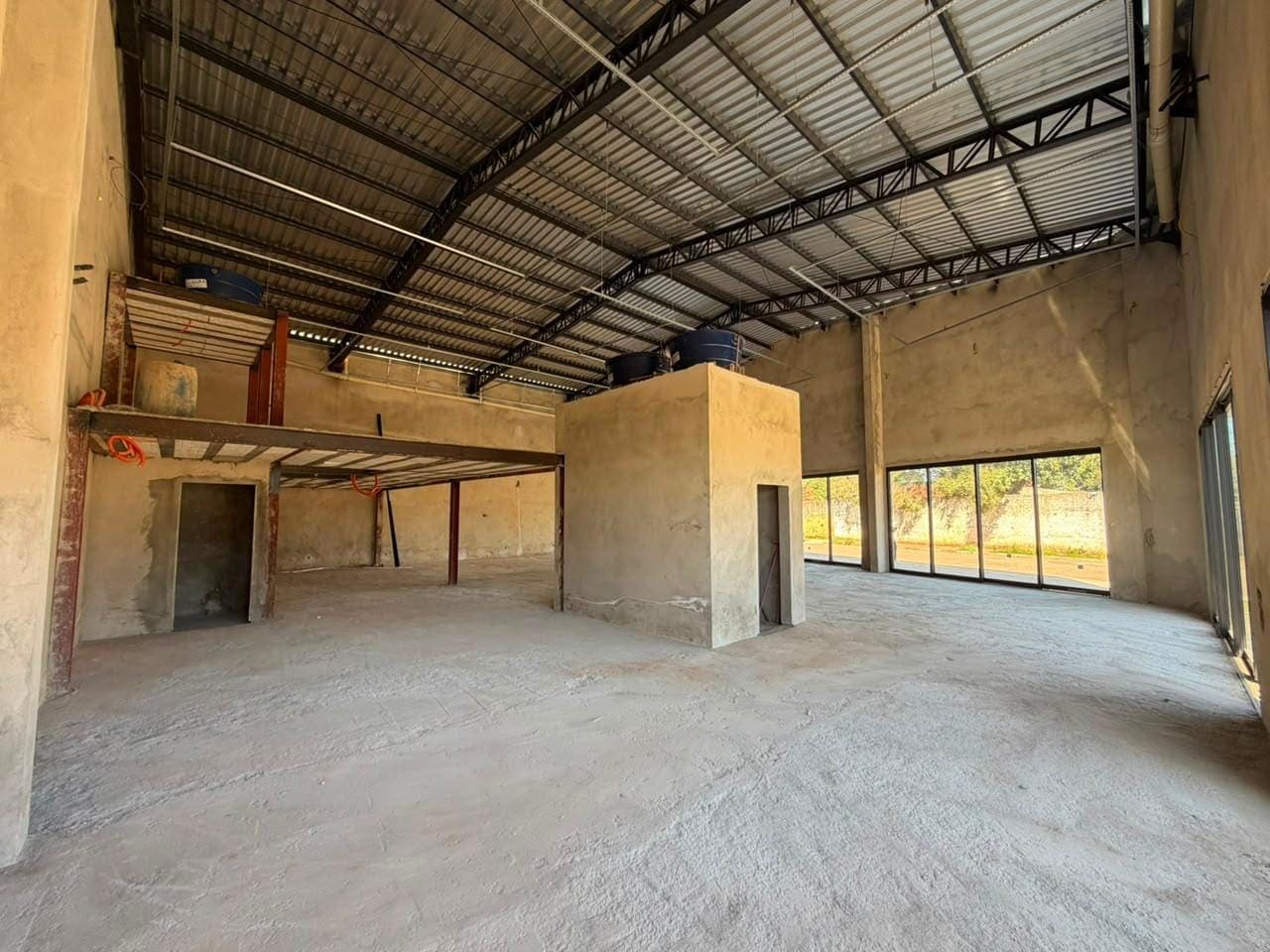 Interior com pé-direito alto e estrutura metálica