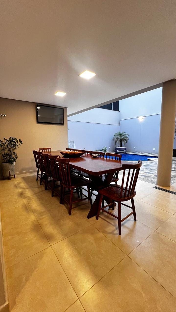 Área gourmet com mesa e vista para a piscina