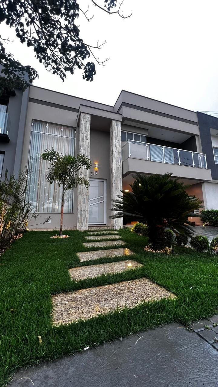 Fachada da casa com jardim e caminho de pedras